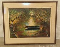 Framed print of a small boat floating in a forest water scene, showing overall condition and framing.