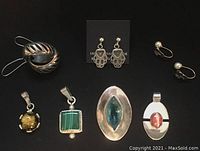 Full set of sterling silver earrings and pendants displayed on black background, includes two pairs of pierced earrings, one pair of pearl slip-on earrings, and four pendants with various stones