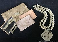 Group shot of necklace, pendant, wallets and mirror