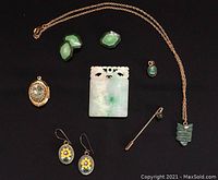Full overview of the lot showing carved jade chop, various pendants, mosaic earrings, stick pin, cufflinks, and chain necklace with jade owl pendant.