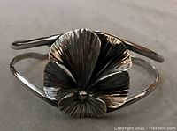 Front view of cuff bracelet showing layered pansy motif and double-band design.