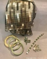 Full view of the jewelry set with scarf, showing three bangles, two pins, and a paneled bracelet along with the poly scarf in earth tones.