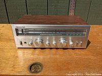 Front view of Soundesign Model 5145 stereo receiver showing wood grain top, silver front panel with multiple control knobs, tuning dial, and button indicators.