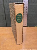 Spine view of the hardcover showing the green label with gold lettering and part of the slipcover.