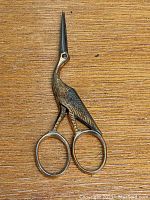 Front view of the vintage Weber embroidery scissors with bird-shaped brass handle and pointed blades