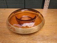 Full view of round amber depression glass bowl with rolled edge showing the etched gilt decorative band around the perimeter.