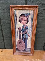 Full view of framed print showing standing boy with mandolin in harlequin outfit.