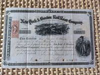 Full stock certificate showing all printed text, artwork including steam locomotive, revenue stamp and signatures.