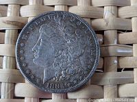 Obverse side of the 1883 P Morgan silver dollar coin showing Lady Liberty's profile and the date.
