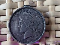 Obverse side of 1922 Peace silver dollar in bezel with Liberty's profile and visible year 1922.