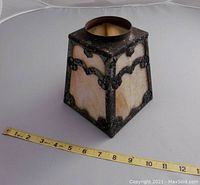 Front and side views of the slag glass and wrought iron lighting shade with measuring tape for scale.