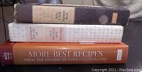 Three hardcover cookbooks stacked together showing spines and top text: 'Mastering the Art of French Cooking Volume Two' by Julia Child and Simone Beck, 'Mastering the Art of French Cooking' by Simone Beck, and 'More Best Recipes'