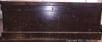 Side view of the wooden tool chest showing the dark stained wood and rectangular shape.
