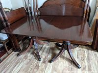 Full front angle view of mahogany table showing rectangular top, pedestal legs, and polished surface.