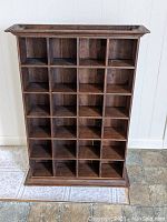 Front view of the wooden pigeon hole cupboard showcasing 24 square slots for storage or display.