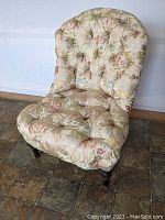 Full view of slipper chair with floral silk upholstery and diamond tufting, shows overall condition and missing 2 casters.