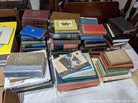 Wide view of stacked antique and collectible books on a table