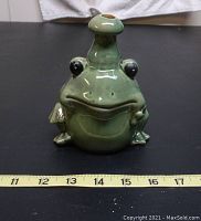 Front view of green pottery frog with scale showing approx 5.25 inches tall