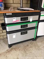 Front view of Stanley tool cabinet showing three drawers with labels and a wood look top.