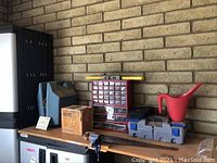 Items arranged on a table including the metal cabinet organizer, house scale, and watering can