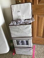 Three fabric containers stacked, filled with wrapped crystal glassware items.