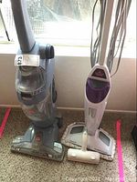 Hoover FloorMate vacuum, Bissell steam mop, and lint roller side by side on carpet