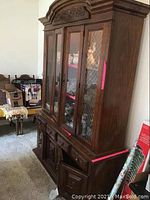 Full view of the two-piece wooden hutch showing glass upper section with diamond pattern glass door and bottom cabinets with drawers and doors.
