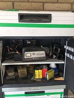 10 Amp battery charger, cords, metal locks, hardware boxes, gloves in drawer and storage compartments.