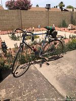 Side view of the Schwinn Le Tour bicycle outdoors showing blue frame, drop handlebars, flat tires, and attached saddle bag.