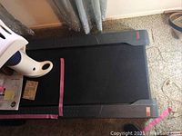 Top down view of treadmill belt and surrounding floor area.