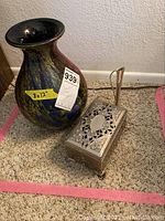 Photo showing large multicolored glass vase and silver-tone musical jewelry box with intricate cut-out pattern.