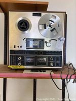 Front view of Akai reel-to-reel tape deck with two metal reels mounted