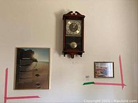 Wall-mounted Citizen wood-cased clock centered between two framed pictures: Footprints poem with beach footprints on the left and desert landscape photo on the right.