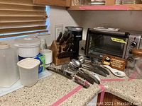 Countertop overview showing Black & Decker toaster oven, Keurig coffee machine, knife block and utensils