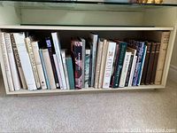 Shelf of hardcover art books showing titles including Etruscan Sculpture, Auguste Rodin, Donatello, City of Baroque and Gothic, Adventures in Art.