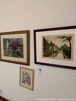 Three framed art prints hanging on a white wall, showing general layout and details of each print.