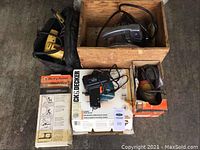 Overview photo showing wood carrying case with Porter-Cable circular saw, boxed Black & Decker finishing sander, jigsaw, Guidemate and drill accessories grouped together.