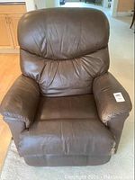 Full front view of the brown leather La-Z-Boy rocker recliner showing the cushioned seat, armrests, and backrest.