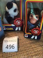 Shows Carl wind-up panda and monkey toys in original blue boxes with logos and window displays.