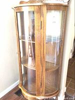 Full front view of oak hutch with curved glass door and side panels
