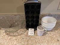 Full view of Keurig coffee pod holder with glass bowl, small white bowls, and spice grinder on counter