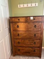 Front view of 6 drawer tall boy dresser showing all drawers and metal ring handles.