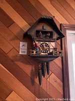 Full front view of wall-mounted chalet-style cuckoo clock showing overall design and condition