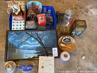 Overview photo showing many items including the framed lake painting, tins, Charlie Weaver bartender figure, novelty dispenser base, Dog on Duty plaque, and small household items.