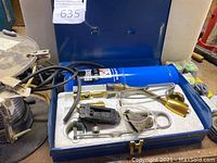 Blue metal welding kit case open showing Bernzomatic propane gas canister and welding torch accessories inside