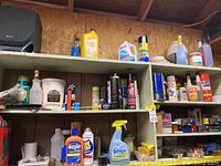 Shelves with assorted nails, screws, household chemicals, cleaning sprays, and other products.
