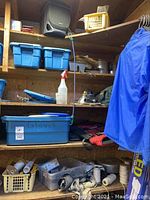 Overview of wooden shelving with blue storage bins, gloves box, and hanging blue jacket