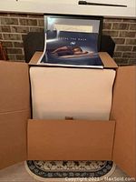 Elevated foam bed pillow inside an open cardboard box showing its size and condition.