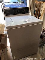 Front angled view of white top load Maytag washer showing lid closed and general exterior condition.