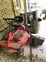 Front angle view of Snapper lawn tractor showing steering wheel, seat, mowing deck, and some accessories on the side